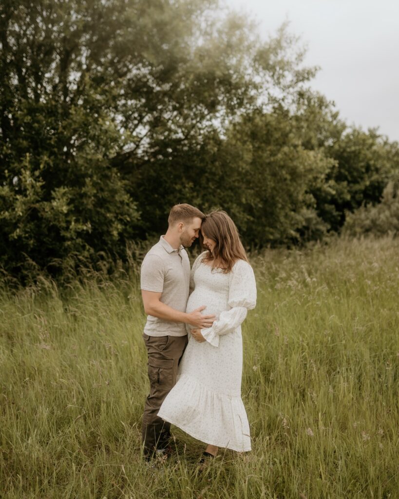 Maternity Couple In Meadow